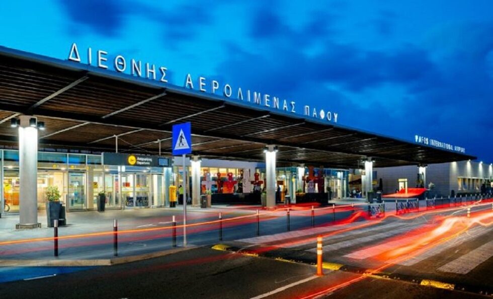 Exterior view of Paphos Airport showcasing its modern architecture and entrance, with travelers arriving and departing.