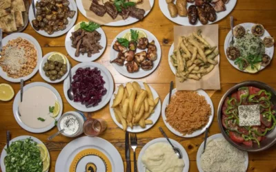 A colorful Cyprus meze platter featuring an assortment of dishes, including hummus, tzatziki, olives, grilled vegetables, and various meats, served with pita bread