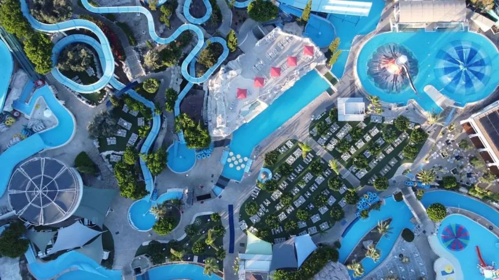 A vibrant photo of Aphrodite Waterpark in Paphos, featuring colorful water slides, wave pools, and families enjoying the attractions.