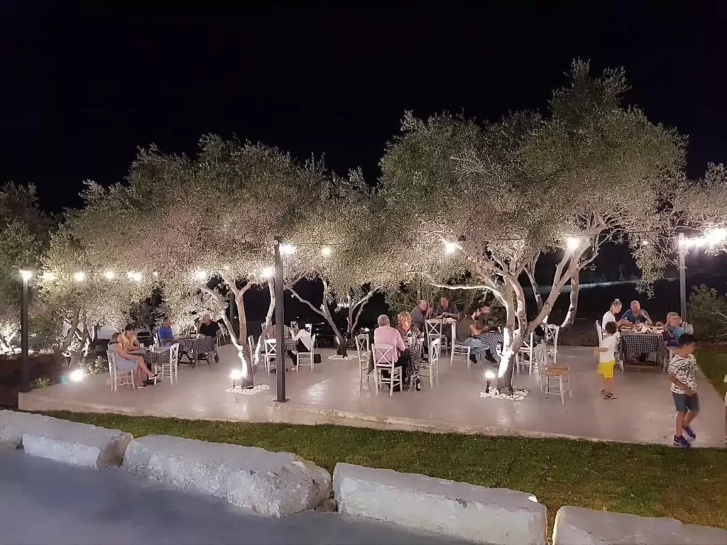A cozy outdoor seating area at Solos - Kebab House & Beer Garden, featuring tables, umbrellas, and string lights at dusk.