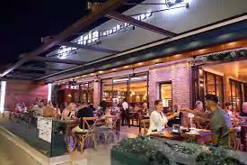 Photo of the outdoor terrace at Andria's Steak and Seafood restaurant, featuring wooden patio furniture, colorful flower pots, and views of Coral Bay.