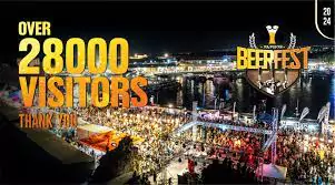 Thank you message displayed on a banner at the Paphos Beer Festival, surrounded by smiling attendees celebrating together